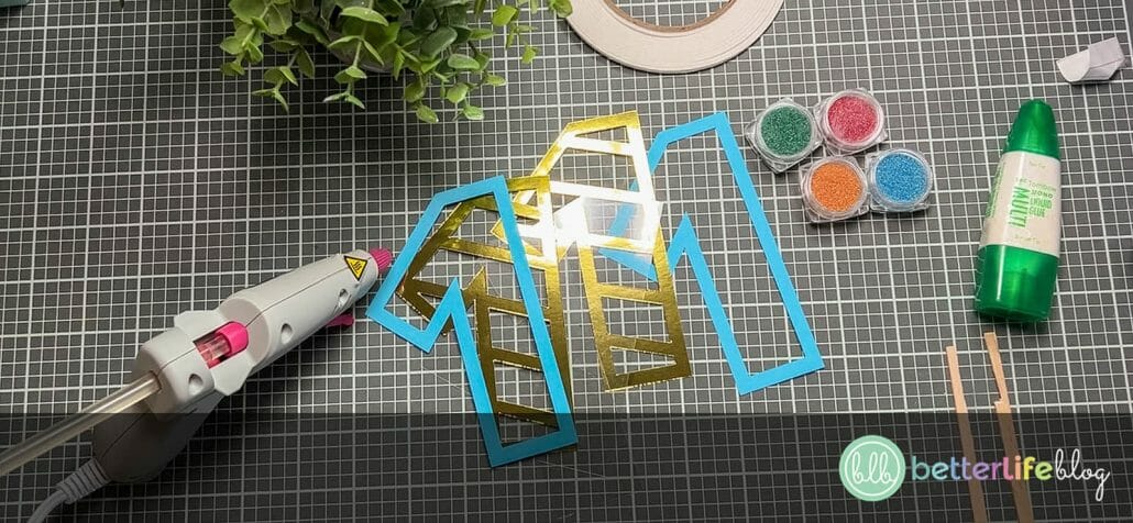 Cardstock and acetate cut-outs, freshly cut by a Cricut machine and other supplies required to make Birthday Shaker Cake Toppers.