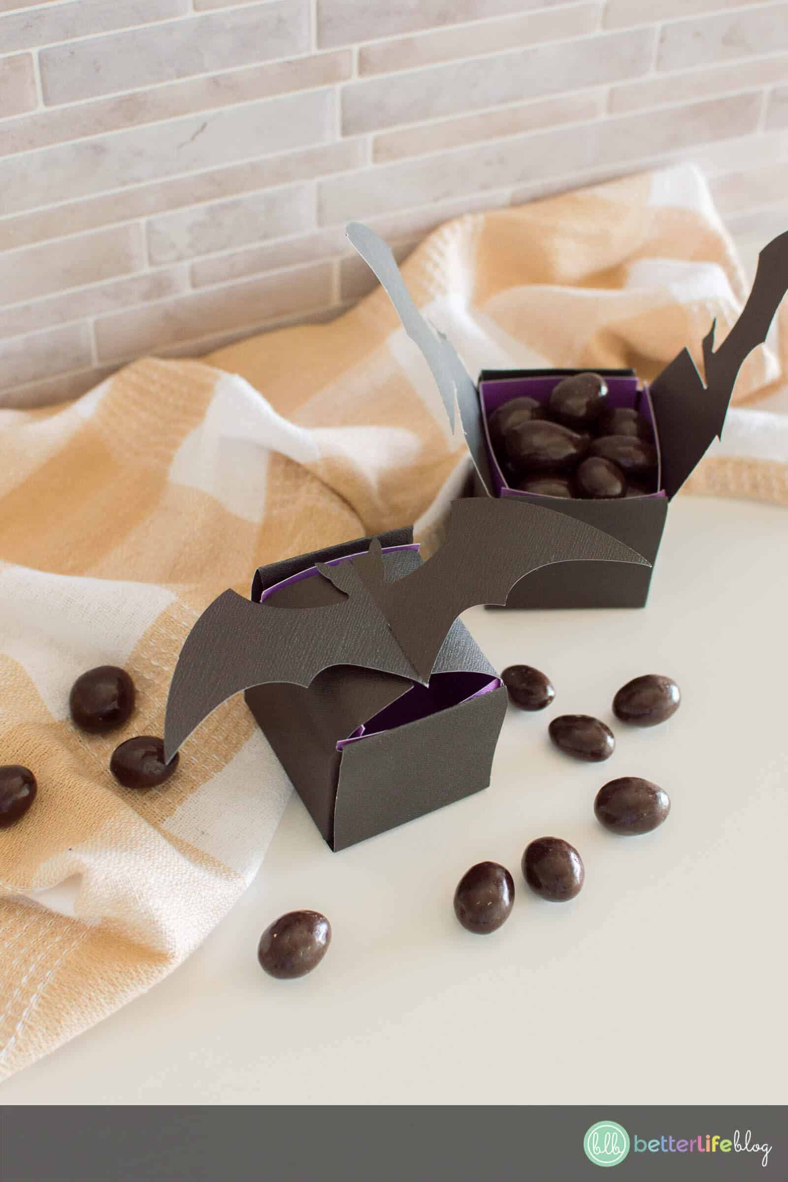 Halloween Bat Treat Box filled with chocolate-covered almonds and surrounded by a plaid napkin