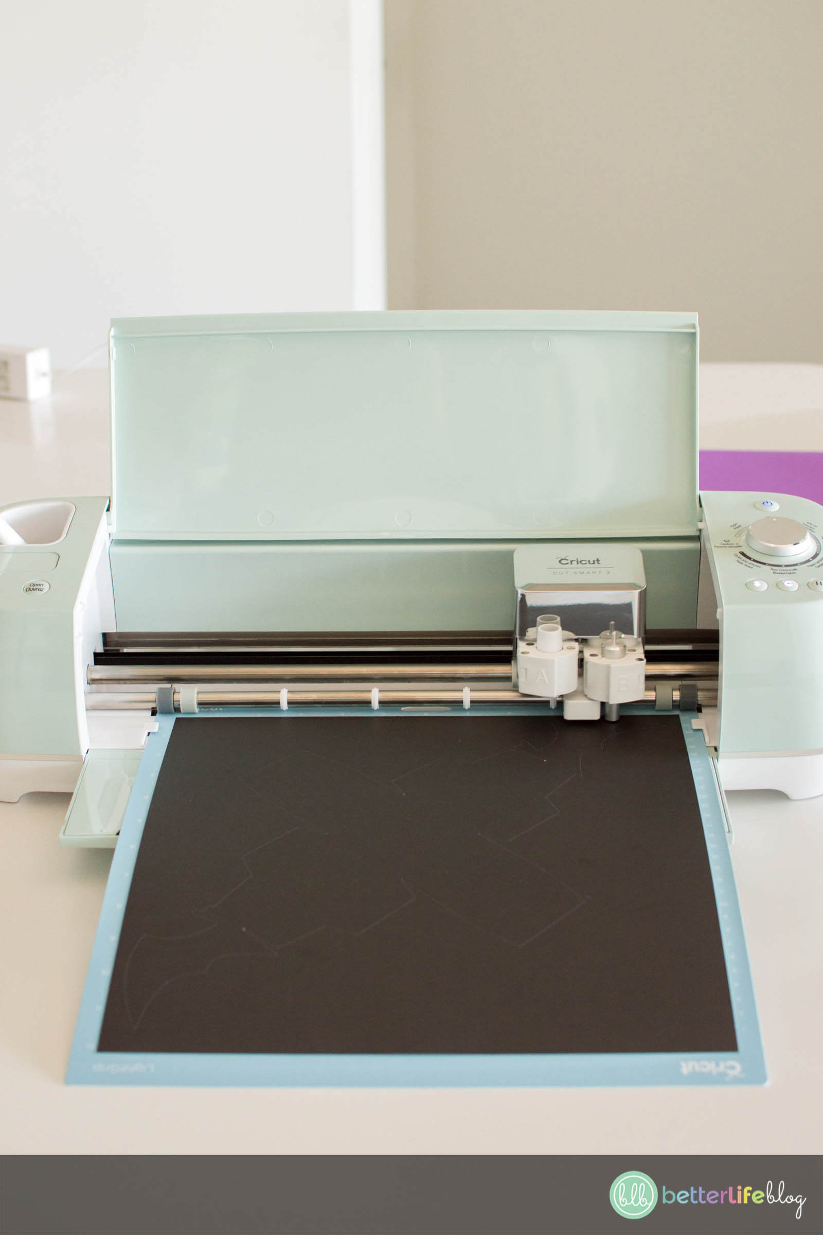 Black cardstock on a grip mat being loaded to a mint green Cricut