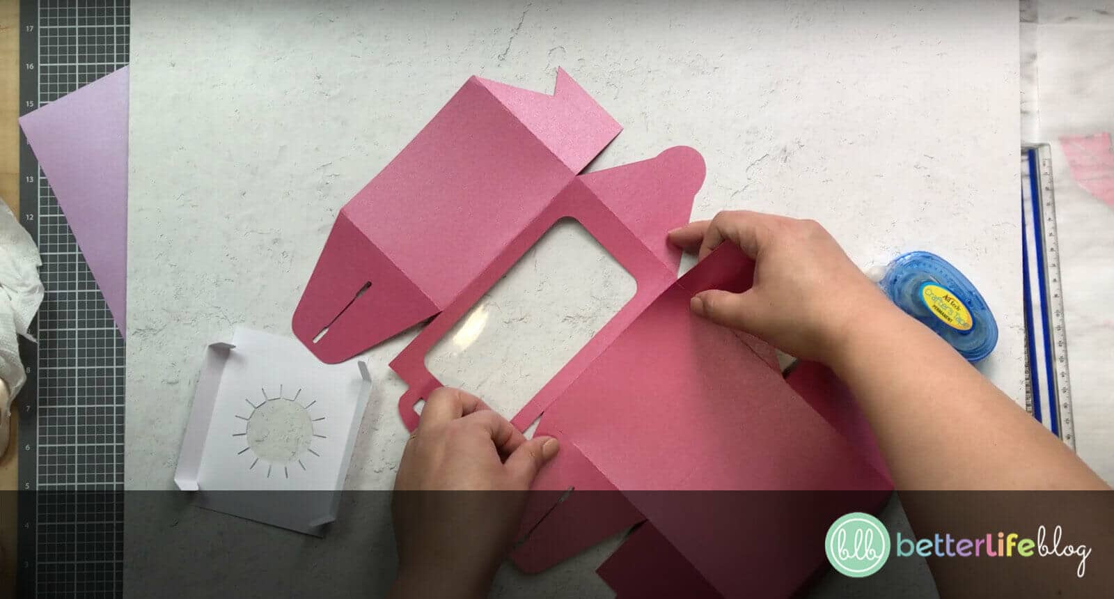 Adding a piece of cut-out pink cardstock to another piece of pink cardstock
