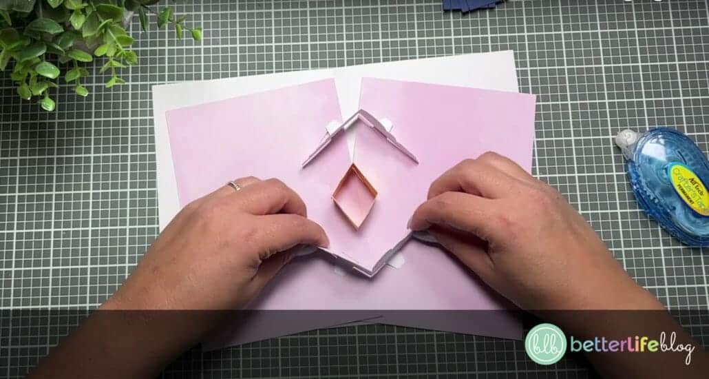 Placing the cloud pieces on the rectangular pieces to complete a Cricut Hot Air Balloon Pop-Up Card