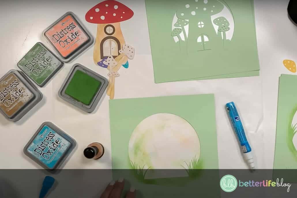 Adding Distress Oxide Ink to cardstock pieces to make a shadow box with a Cricut